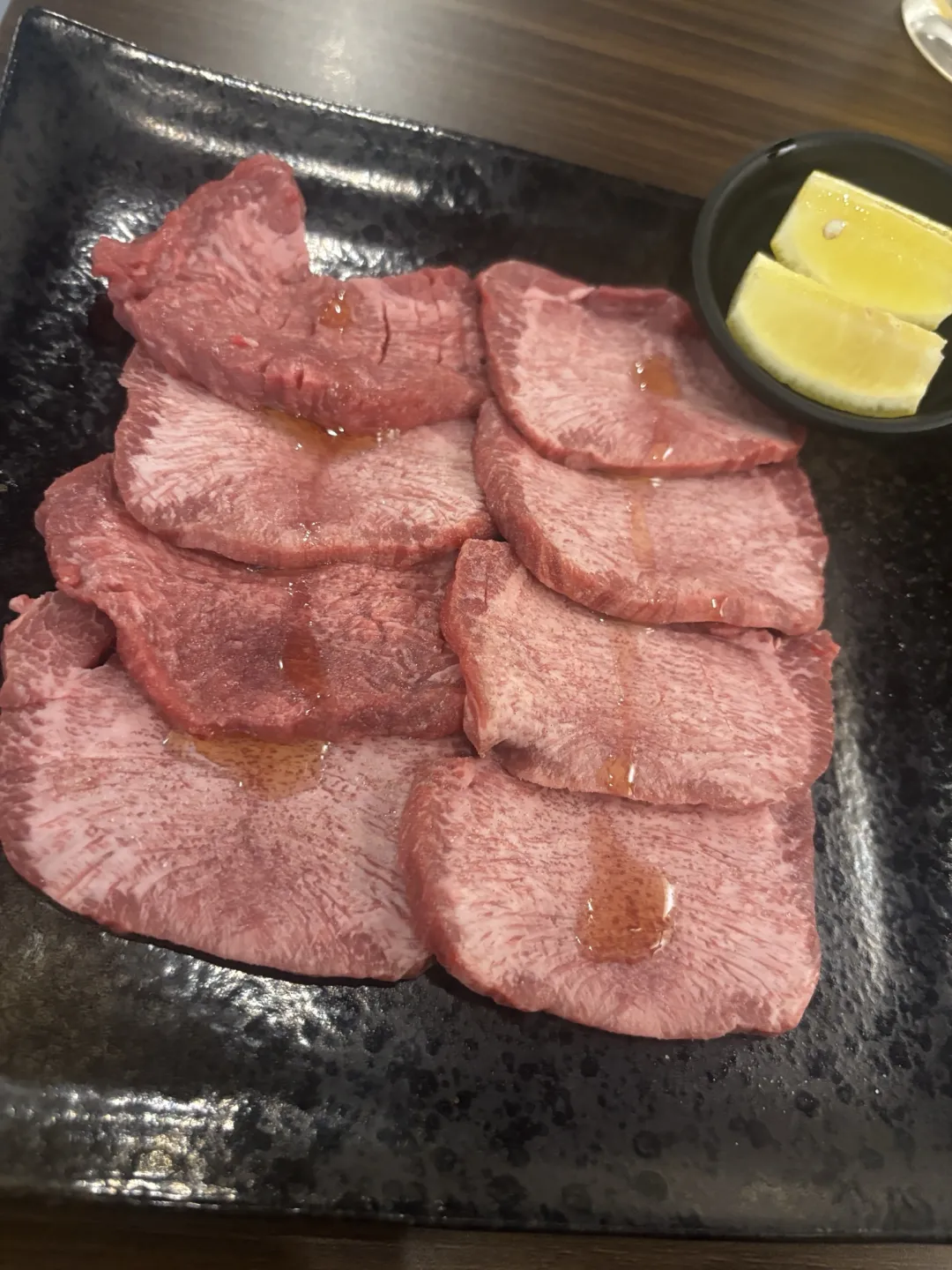 소금 간을 한 우설 여러 장과 레몬 조각